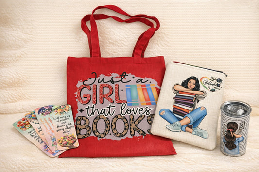Red tote bag with 'Just a girl that loves books' design, white pouch with graphic, and can with graphic on a light background. Bookish gift bundle featuring a red tote bag, illustrated book sleeve, tumbler and floral bookmarks on a cream background. designed by Roxxana Roveno