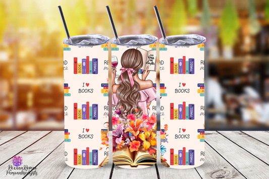 Three insulated tumblers with a design of a girl holding a book and a glass of wine, surrounded by books, on a wooden surface.