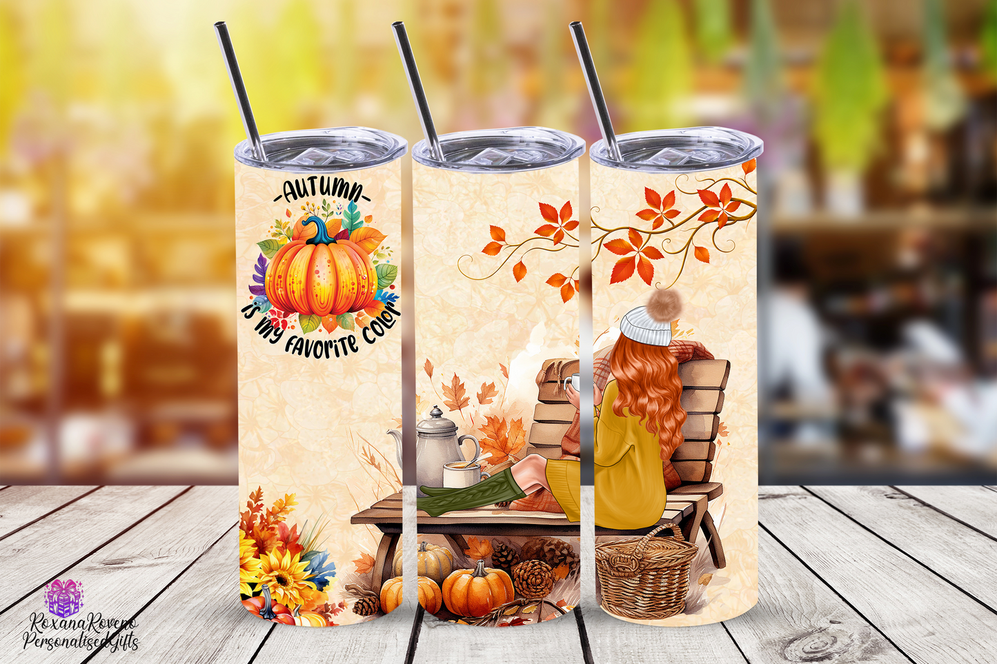 Three fall-themed tumblers with designs of pumpkins, leaves, and people in a cozy setting on a wooden surface.