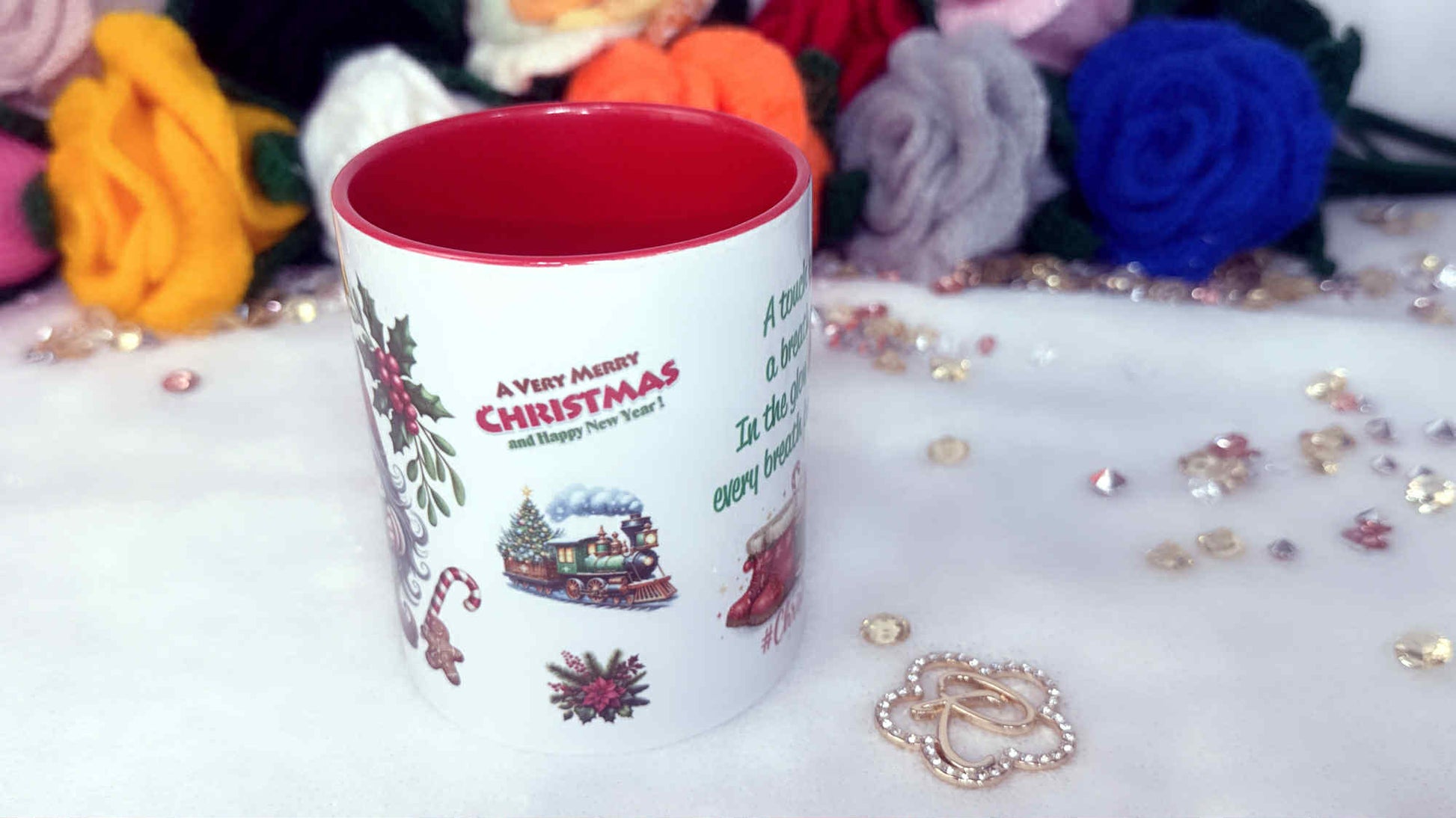 Christmas-themed mug with decorative elements on a white surface with flowers and jewelry.