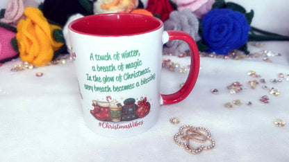Mug with Christmas-themed text and graphics on a decorative surface with flowers and jewelry.