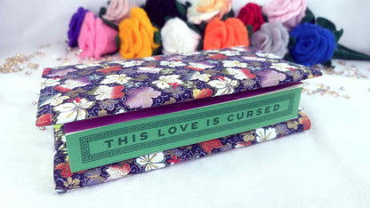 Floral-patterned book with 'This Love is Cursed' text on a white background Handmade book cover by Roxana Roveno