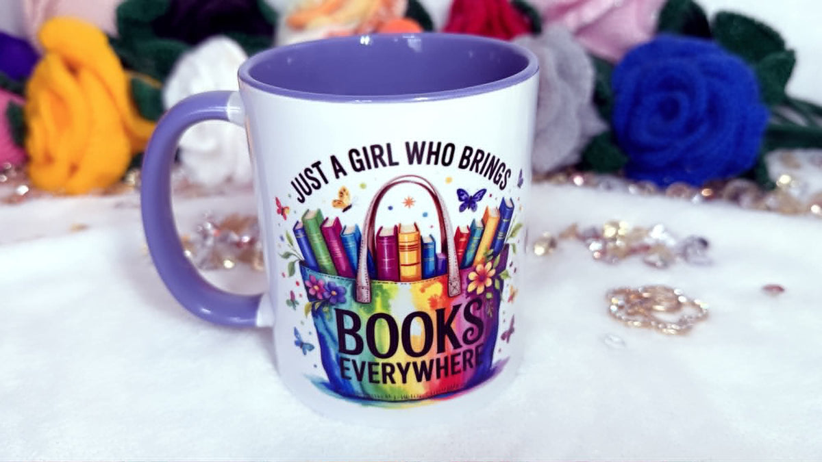 Mug with colorful design and text 'Just a girl who brings books everywhere' on a white surface with flowers and Colourful book lover mug featuring a books tote bag design and reading quote, purple handle ceramic coffee cup
