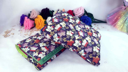Colorful floral-patterned pouch with a green zipper on a white background Handmade book sleeve and book cover by Roxana Roveno