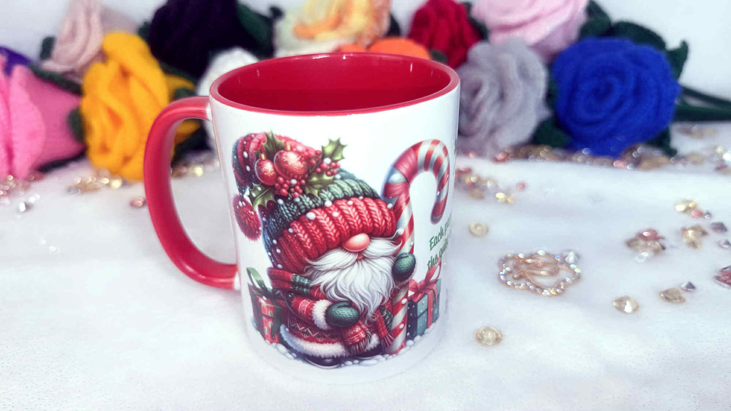 Mug with a festive design of a gnome and berries on a white surface with decorative items.